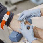 Nurse taking blood sample from patient at the doctors office